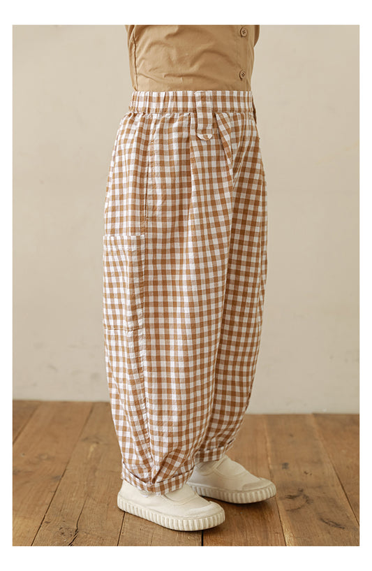 Side view of Ava & Bear London girls’ pleated cotton trousers in gingham print