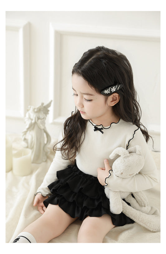 Girl wearing soft stretch top with frill and contrast trim details