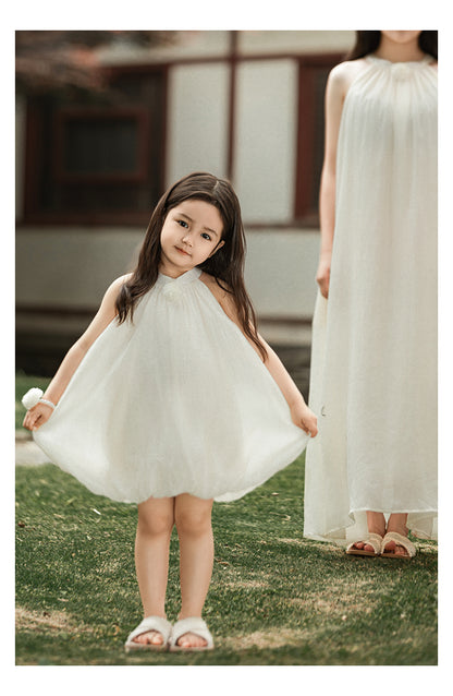 girl wearing summer dress with halter neck and elegant floral accent outdoor