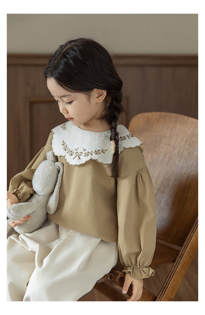 Girls wearinga akhaki cotton blouse with embroidered collar