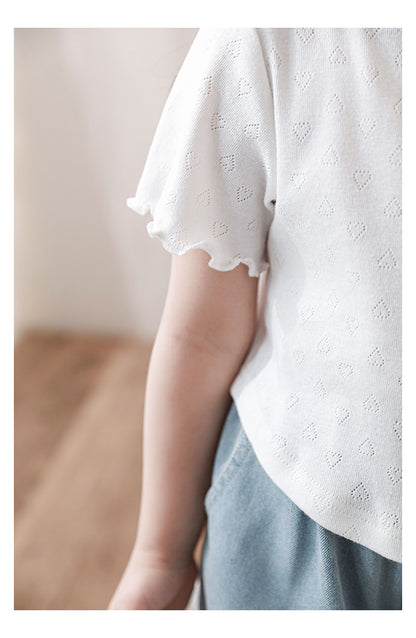 Close-up of frilled sleeve and pointelle texture on T-shirt