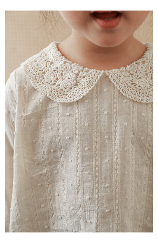 Close-up of lace-trimmed collar on elegant girls blouse