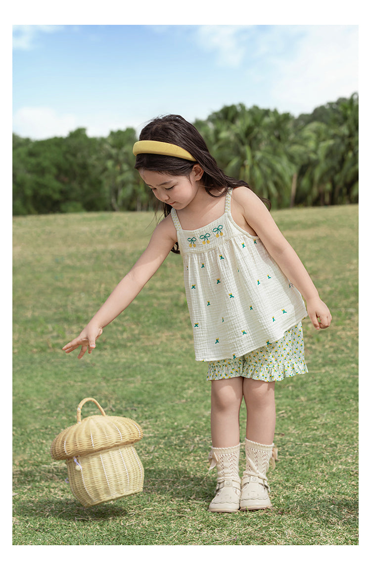 Young girl in a white top with cherry embroidered patterns by Ava & Bear London