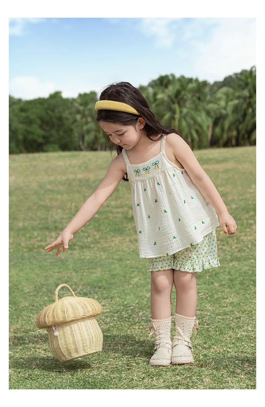 Young girl in a white top with cherry embroidered patterns by Ava & Bear London