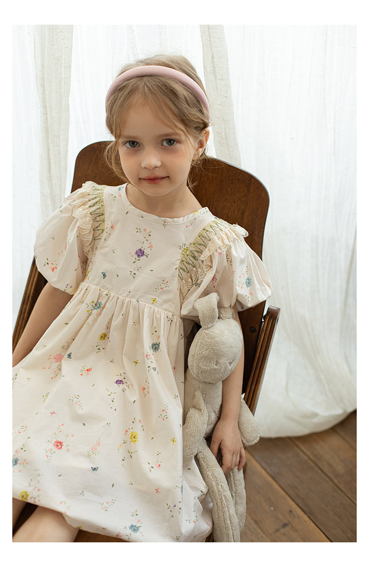 Girl wearing white floral dress with ruffle details and puffed sleeves