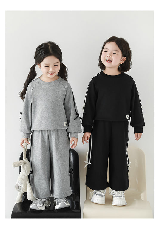 Girls wearing grey sweatshirt and joggers set with ribbon detailing