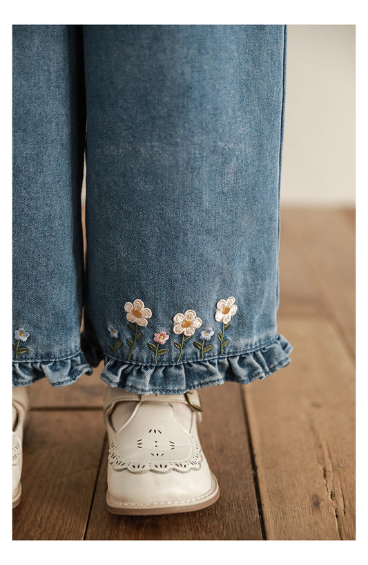 Close-up of floral embroidery on girls wide-leg ruffle jeans